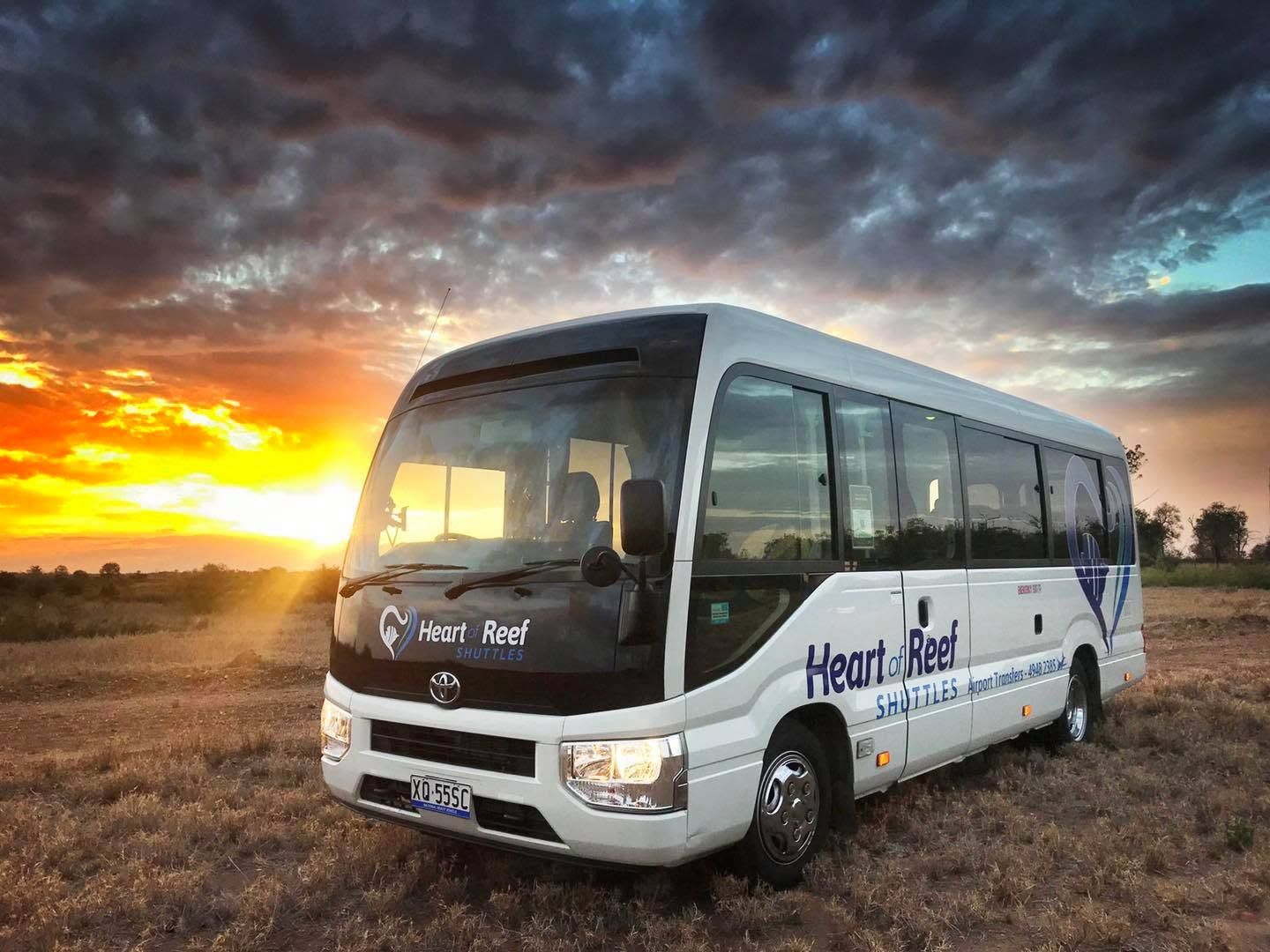 Airport transfer bus with a sunset in the background
