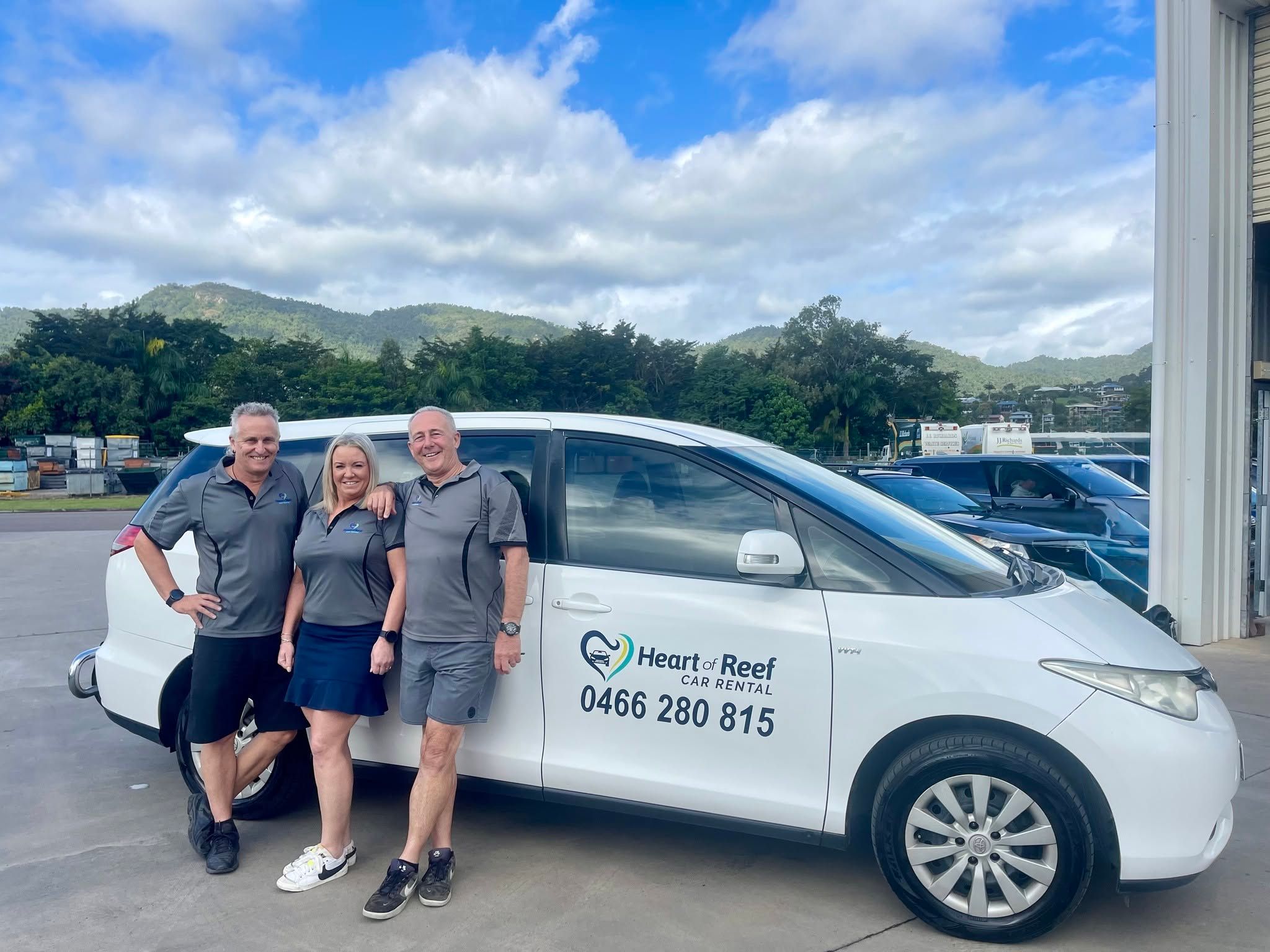 Car rental team standing in front of a white van